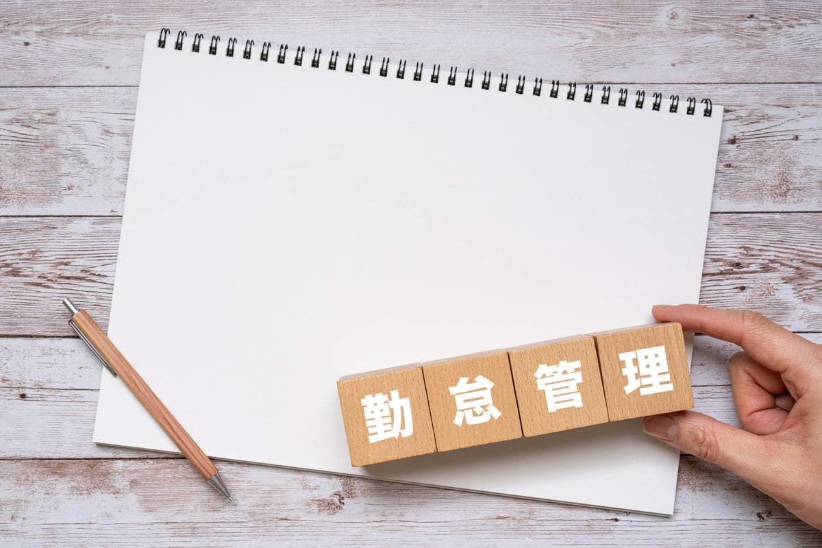 Wooden blocks with "kintaikanri" text of concept, a pen, and a notebook.